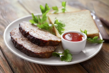 Plate with sliced tasty turkey meatloaf on table