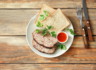 Plate with sliced tasty turkey meatloaf on table