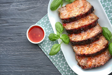 Plate with sliced tasty turkey meatloaf on table