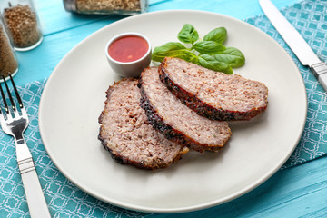Plate with sliced tasty turkey meatloaf on table