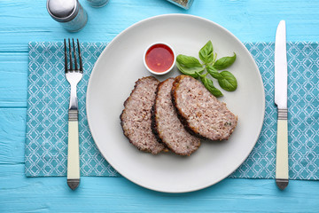 Plate with sliced tasty turkey meatloaf on table