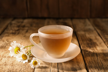 Cup of chamomile tea on wooden background