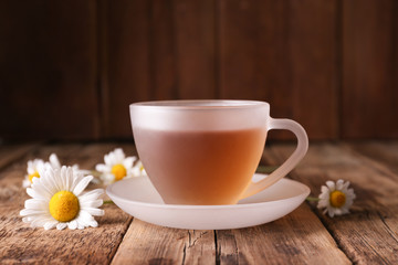 Cup of chamomile tea on wooden background