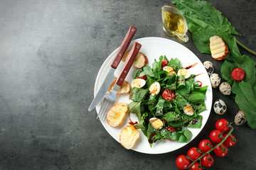 Plate of salad with quail eggs and spinach on table