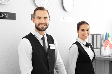 Two hotel receptionists at workplace - obrazy, fototapety, plakaty