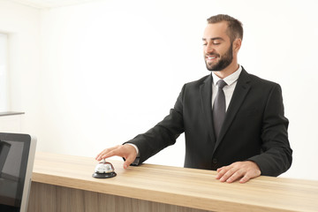 Man ringing in service bell on reception desk