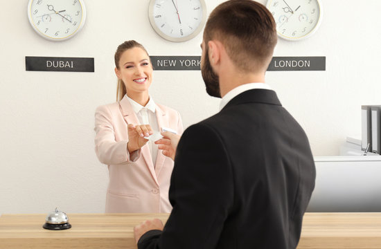 Female receptionist handing card to customer in hotel