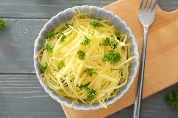 Bowl with flesh of spaghetti squash on wooden board
