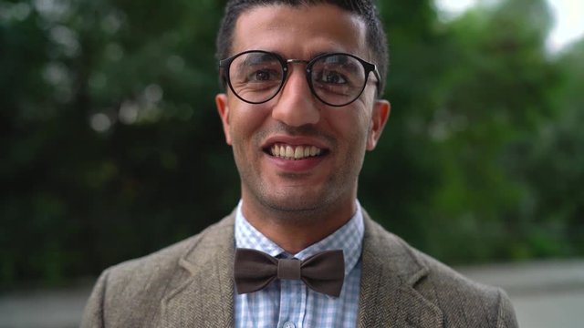 Portrait of a young Arab smiling man in glasses