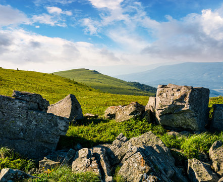 huge boulders on a grassy hillside at sunrise. gorgeous mountain landscape with beautiful sky
