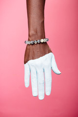 one woman hand, african american painted white hand skin, purple background, jewelery bracelet