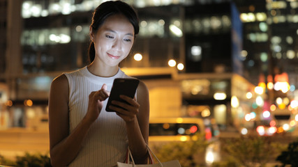 Woman use of cellphone in Hong Kong at night