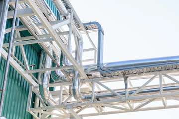Close-up of industrial Steel pipelines of an food and beverage plant with cloudy sky