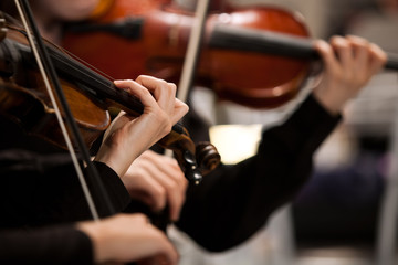 Hands of a girl playing the violin in the orchestra