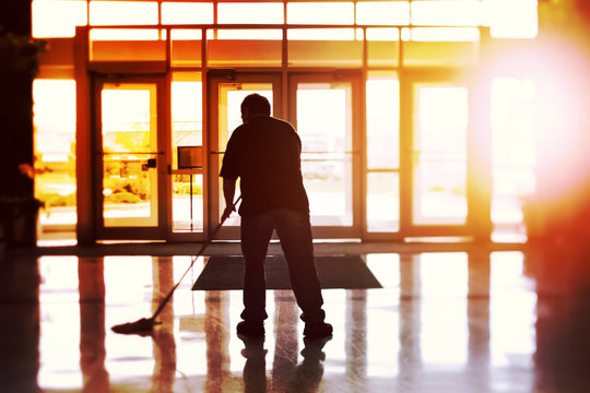Janitor mopping an office floor, shallow focus, tilt shift image