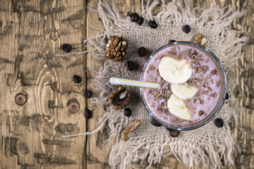 Chopped pieces of banana floating in a chocolate smoothie from top.