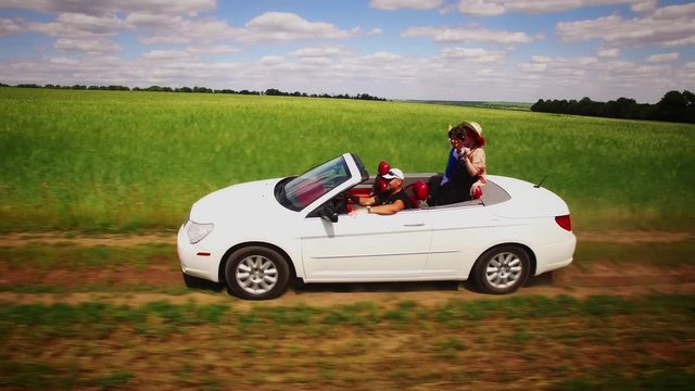 4k Aerial Flying Beside White Convertible Car Driving Along Fields of Wheat