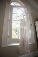 Fototapeta na wymiar Wedding dress hanging on window