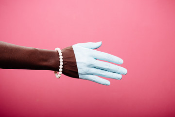 one woman hand, african american painted white hand skin, purple background, jewelery bracelet