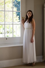 Bride looking away while standing by window