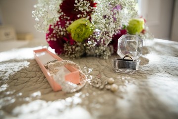 Fototapeta na wymiar Close up of jewelry and bouquet on sofa