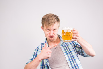 Happy young man holding and pointing on a beer mug
