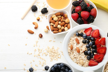 Oat flakes with berries and nuts on wooden table