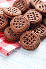 Chocolate cookies with cream on white wooden table