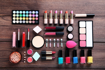 Different makeup cosmetics on brown wooden table
