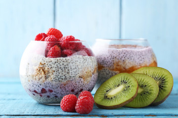 Chia pudding with berries in glasses on blue wooden table