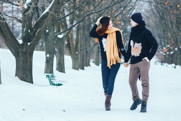 Smiling couple walking in snowy woods together