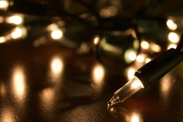 Christmas lights on the table getting ready to be put up. Bright white twinkly lights for the holidays. Christmas eve lighting decoration fun. Translucent xmas tree lights background. 