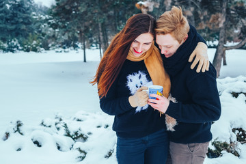 Young couple in love in wood. Man pours tea from a thermos. Close-up