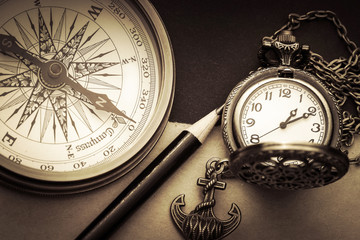 Fototapeta na wymiar Nahaufnahme Kompass und Uhr mit Bleistift und Anker Reisenotizen
