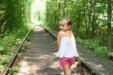  likable and Beautiful child little girl play in the summer. Green nature background
