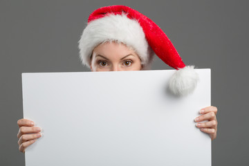 Junge Frau mit Weihnachtsmütze hält ein Plakat