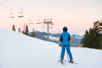 Woman skiers standing on snowy mountain enjoying beautiful mountain landscape on a winter resort at...