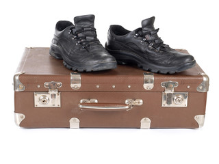 Old suitcase and men's shoes on white background