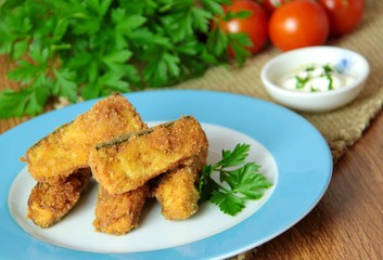 Fried zucchini sticks with dipping sauce and fresh vegetable on background. Close up view.