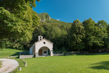 Fototapeta na wymiar Countryside church under the slopes of the mountain. Spiritual Oasis.