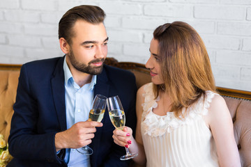 young beautiful couple drinking champagne at home