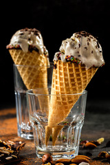 Creamy ice cream with chocolate crumbs in a waffle cone stands in a glass