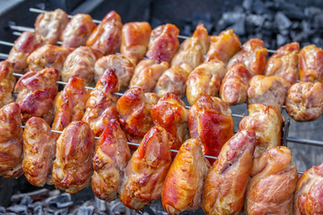 Crispy golden brown pork knuckles on a grill, outdoors barbecue