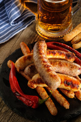Grilled sausages with a glass of beer on a wooden table. Rustic style.