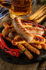 Grilled sausages with a glass of beer on a wooden table. Rustic style.