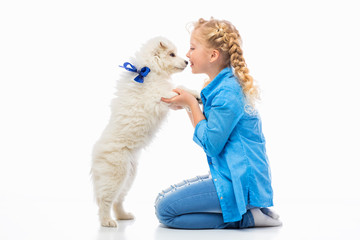 Little girl with a samoyed puppy