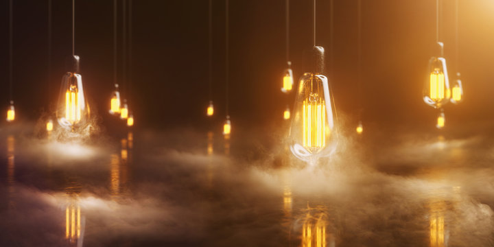 viele Edison Glühbirnen hängen im Raum und leuchten mit warmem Licht umgeben von geheimnisvollem Nebel
