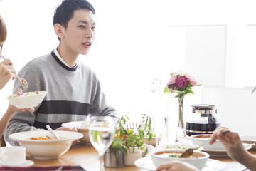 A man who talks with his family while having a meal