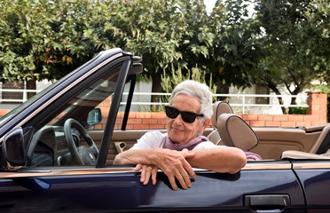 portrait of a senior woman with convertible car