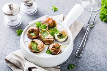 Bourgogne Escargot Snails with garlic herbs butter in white pan on light gray background. Healthy food concept. © Iryna Melnyk